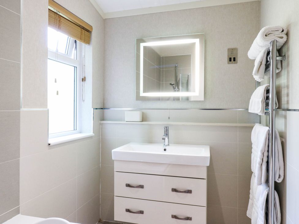 A bathroom with a sink and towels at Oak Lodge Battisford near Stowmarket