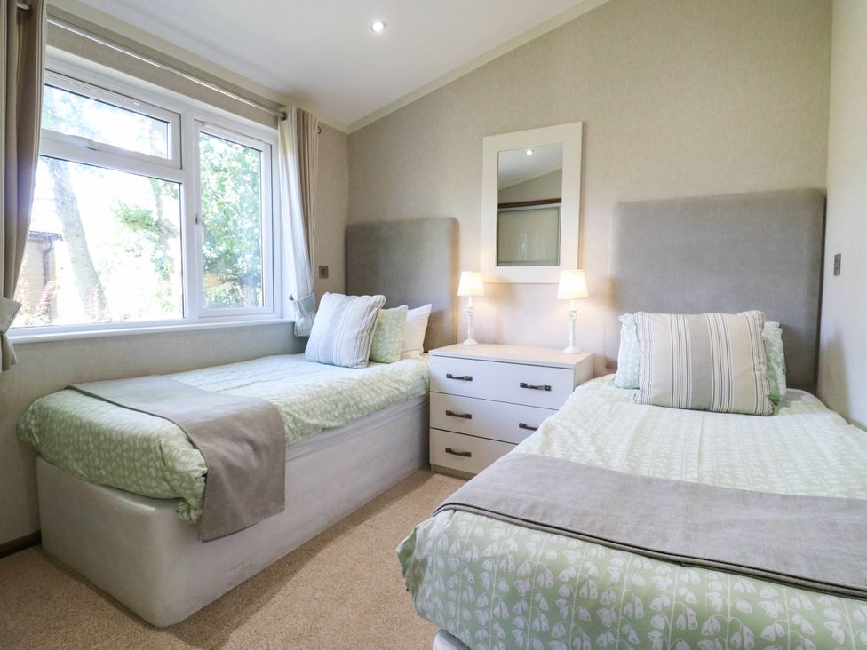A bedroom with two beds and a chest of drawers at Oak Lodge Battisford near Stowmarket