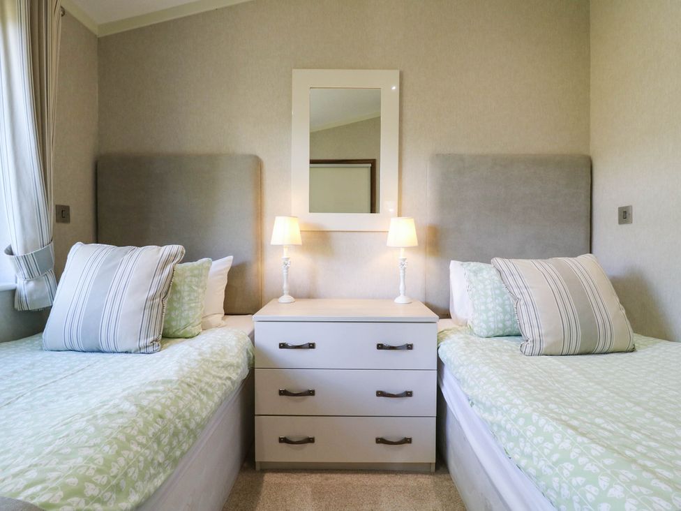 A bedroom with two beds and a dresser at Oak Lodge Battisford near Stowmarket