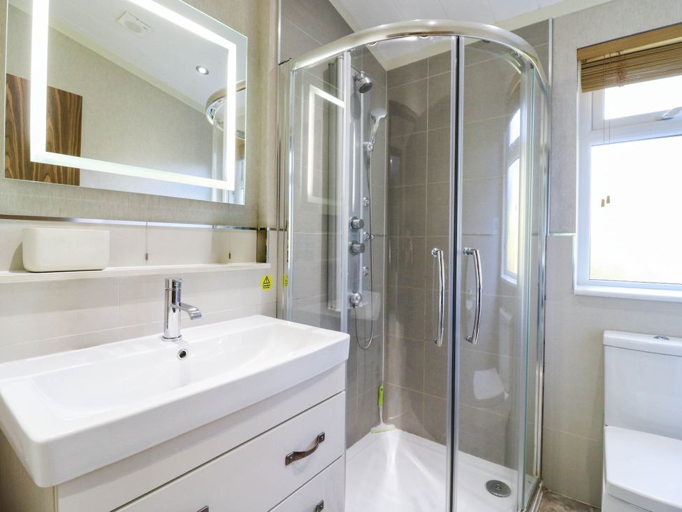A bathroom with a shower, sink, and toilet at Oak Lodge Battisford near Stowmarket
