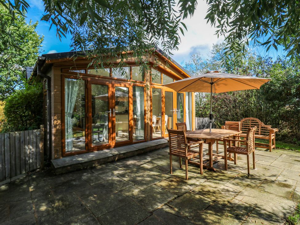A garden with a wooden table and chairs at Oak Lodge Battisford near Stowmarket