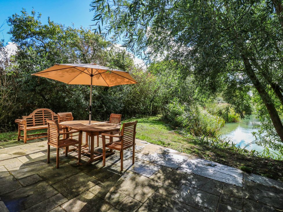 An outdoor dining area with a table and chairs at Oak Lodge in Battisford near Stowmarket