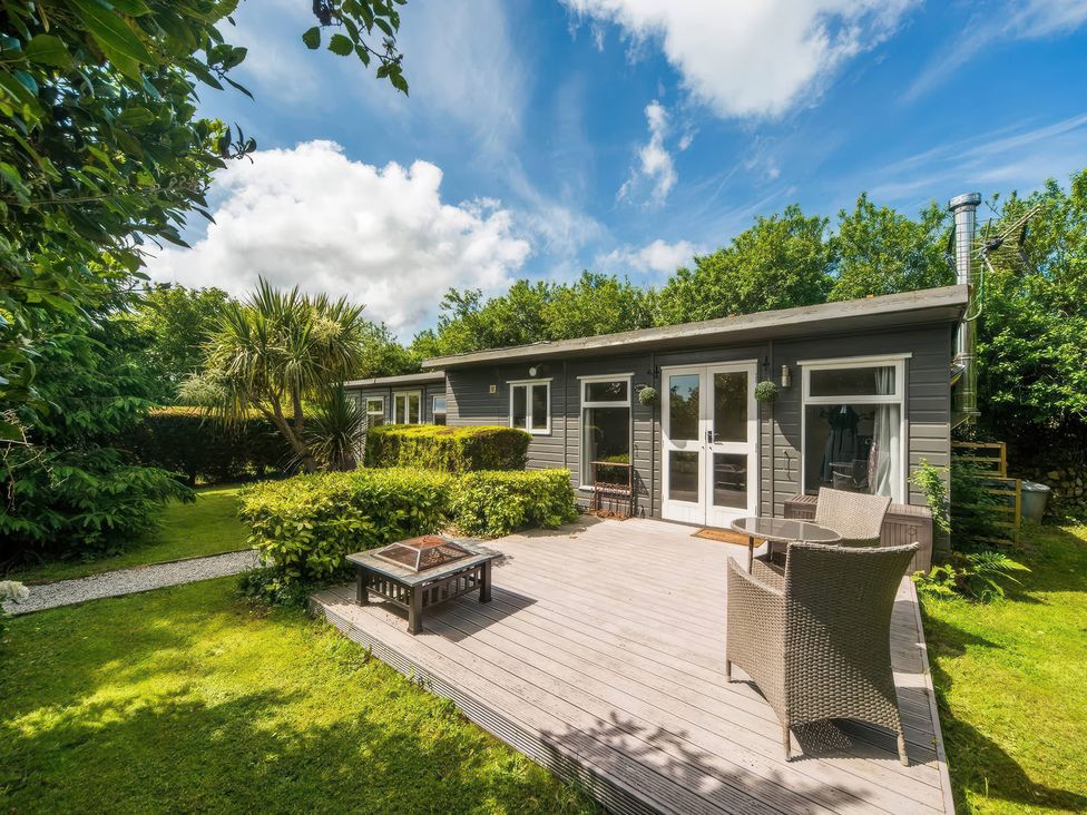 A garden with decking and chairs at cuddle cabin in Constantine