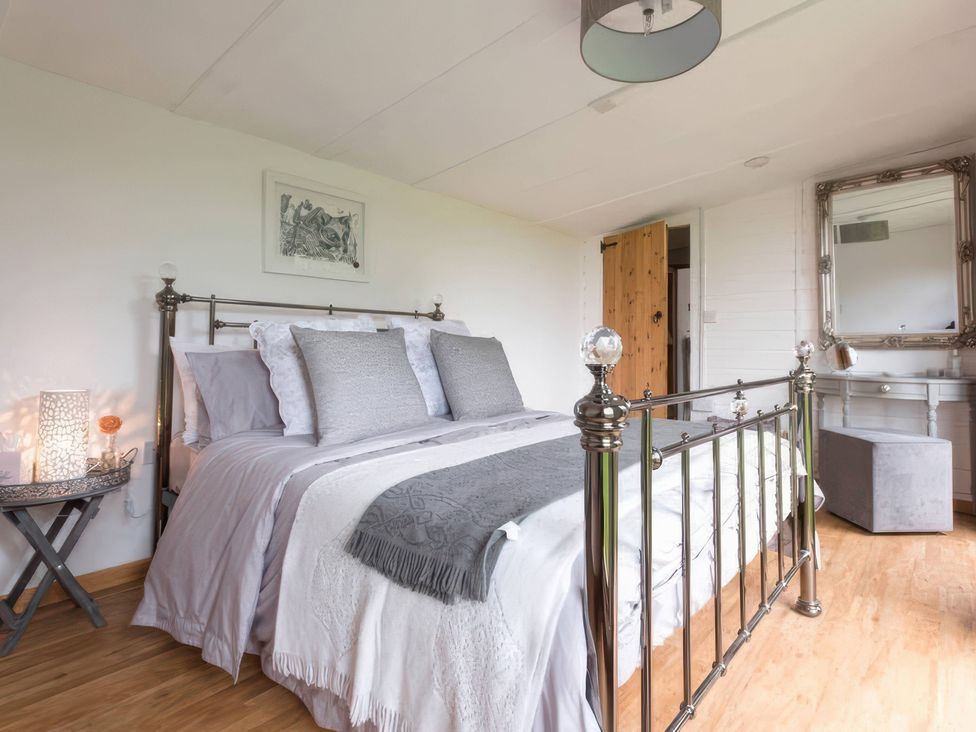 A bedroom with a bed and side table at cuddle cabin in Constantine