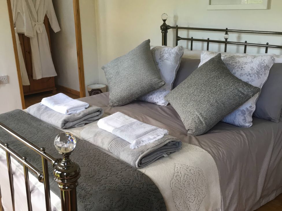 A bedroom with bed and towels at the Cuddle Cabin in Constantine