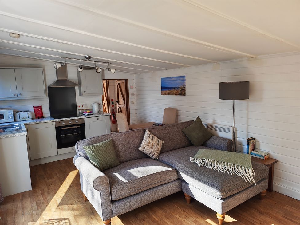 A living room with a sofa and kitchen in Hazel Lodge, Constantine