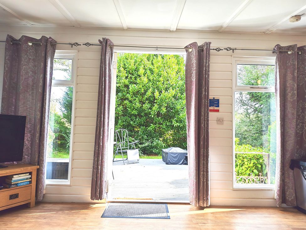 A living room with windows and a view of the outdoor area at Hazel Lodge in Constantine