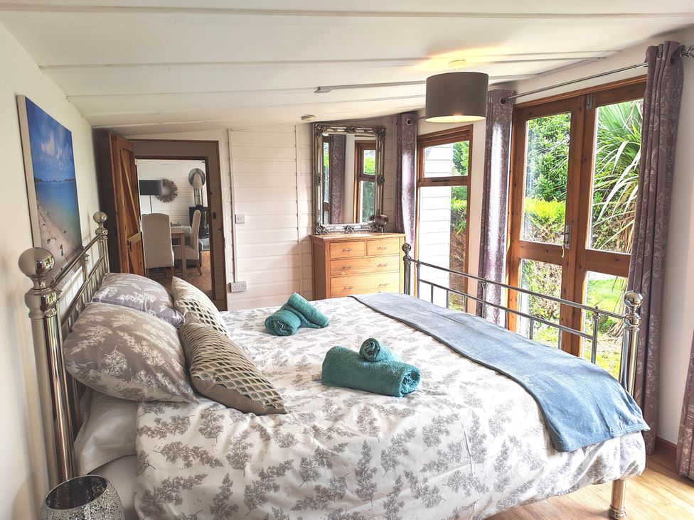 A bedroom with a double bed and large windows at Hazel Lodge in Constantine