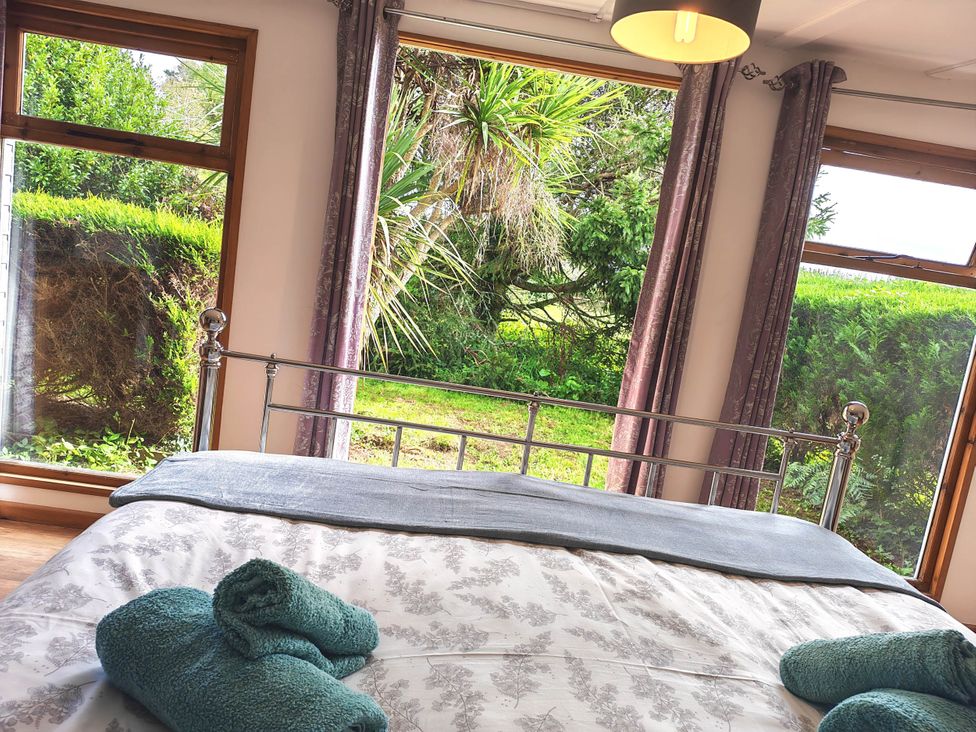 A bedroom with a bed and windows at Hazel Lodge in Constantine