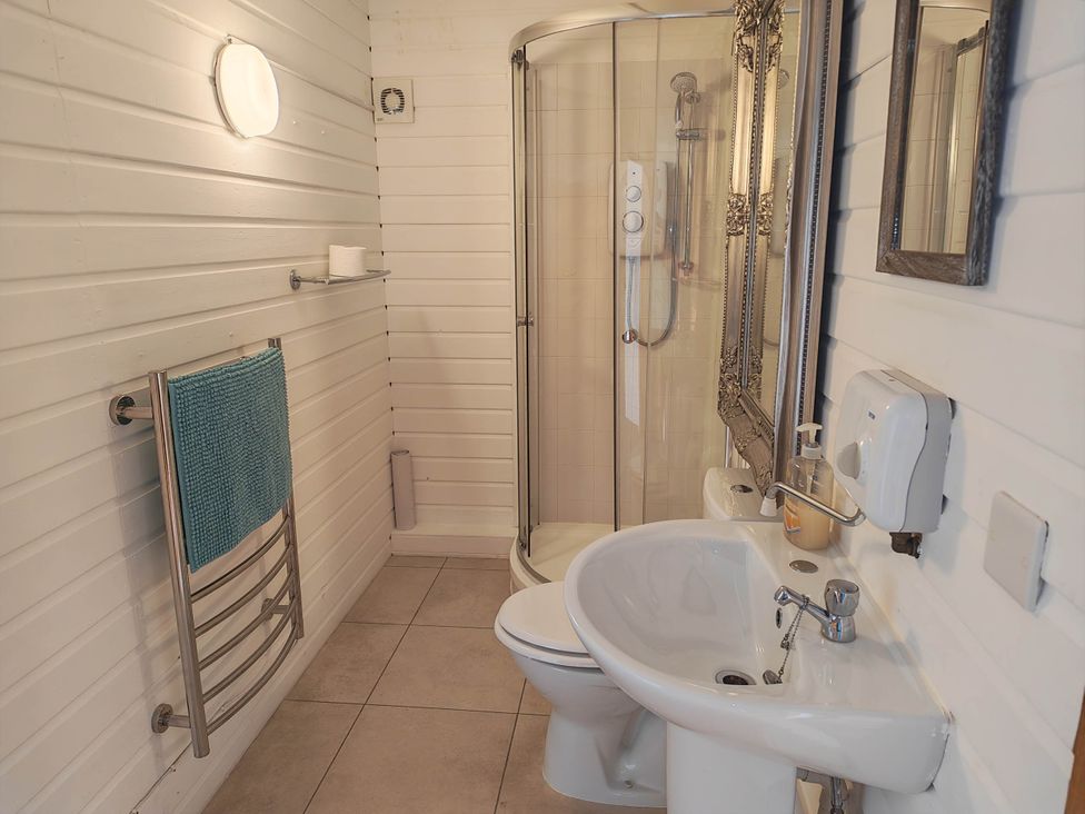 A bathroom with shower, toilet, sink and towel rail at Hazel Lodge in Constantine