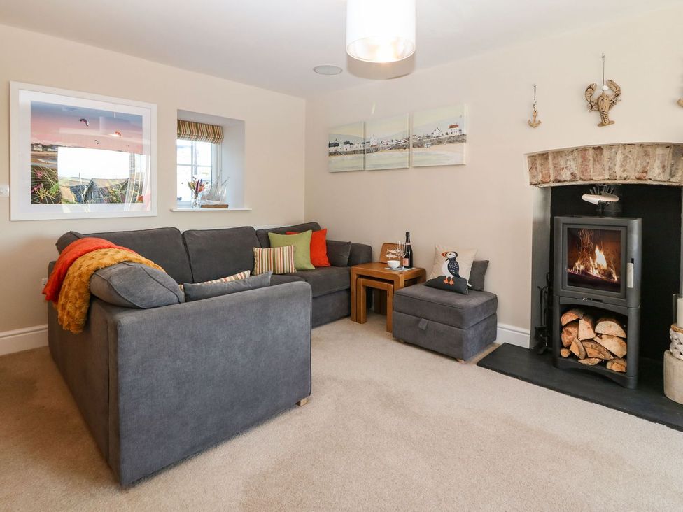 A living room with a sofa and fireplace at Bryn Tirion - Rhosneigr