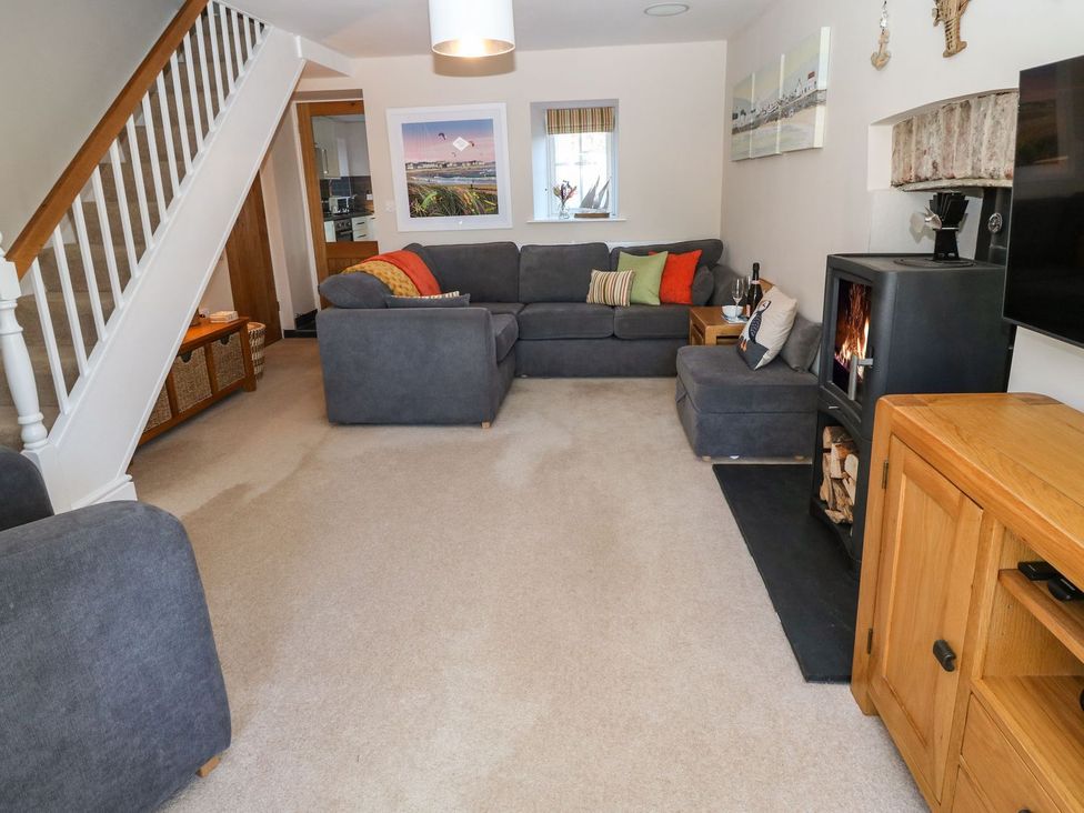 A living room with grey sofas and a fireplace at Bryn Tirion - Rhosneigr