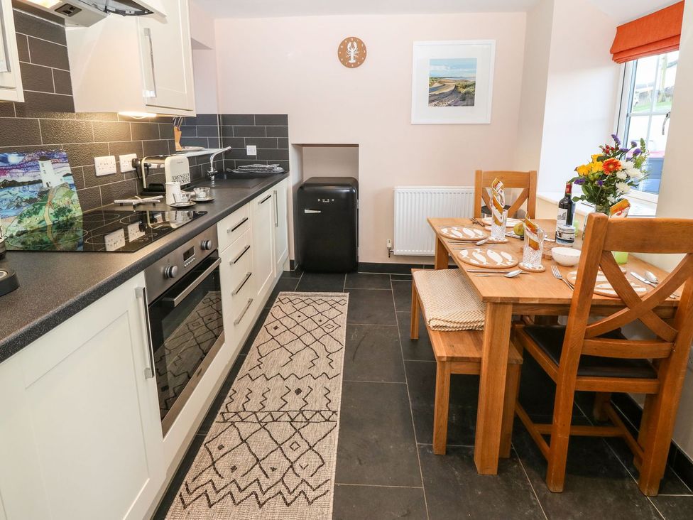 A kitchen with a dining area and table at Bryn Tirion - Rhosneigr