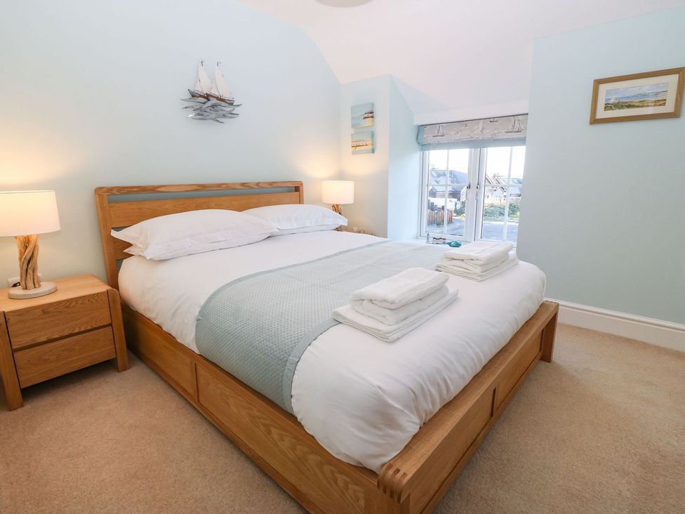 A bedroom with a bed and nightstand at Bryn Tirion - Rhosneigr