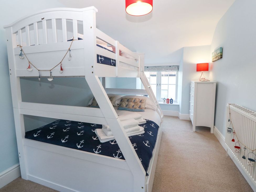 A bedroom with a bunk bed and a double bed at Bryn Tirion - Rhosneigr