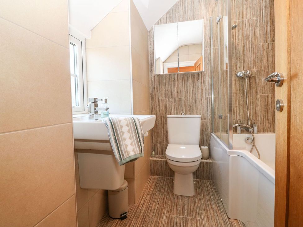 A bathroom with a sink, toilet, and bathtub at Bryn Tirion - Rhosneigr