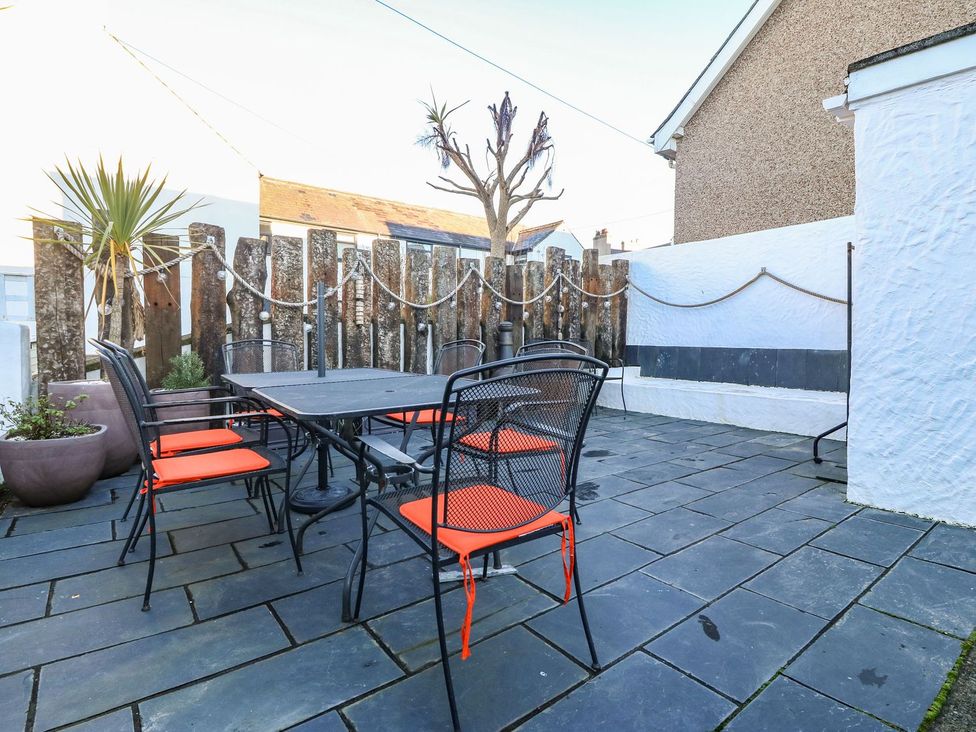 An outdoor dining area with a table and chairs at Bryn Tirion - Rhosneigr