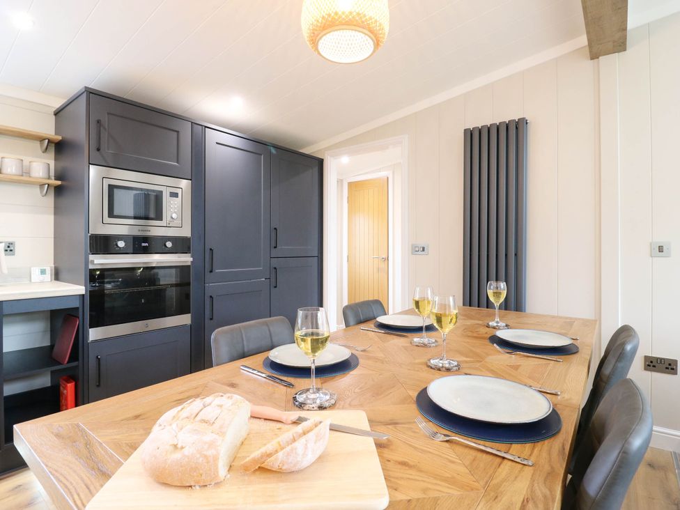 A kitchen with a dining table set for a meal at Cherry Lodge in Battisford near Stowmarket