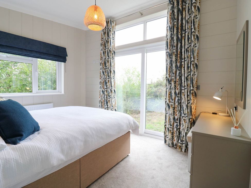 A bedroom with a bed and a window at Cherry Lodge in Battisford near Stowmarket
