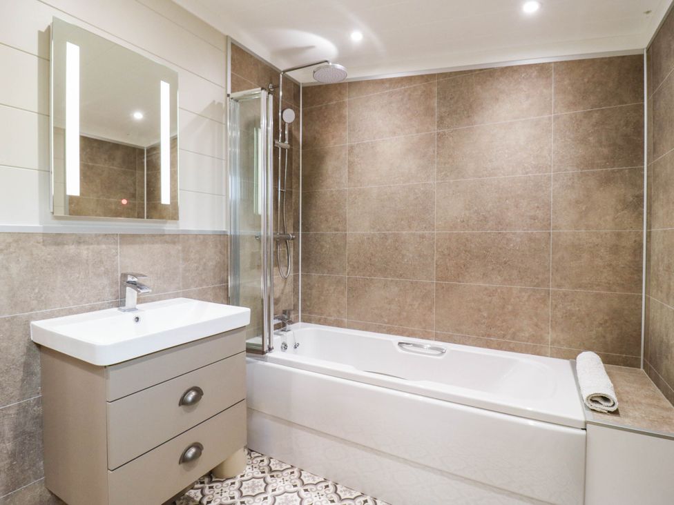 A bathroom with a bathtub and shower at Cherry Lodge Battisford near Stowmarket