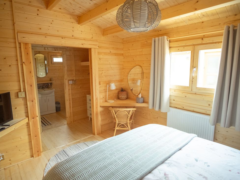 A bedroom with a desk and chair at Willow Lodge in Stowmarket