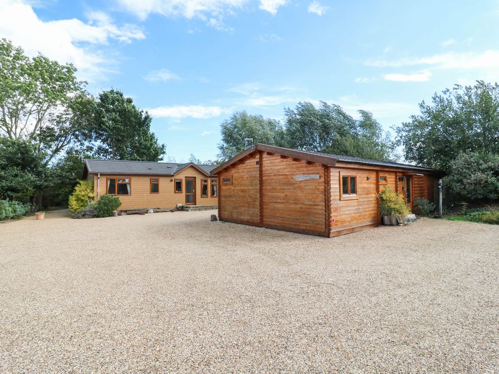 Two houses with a gravel driveway at Willow Lodge in Stowmarket