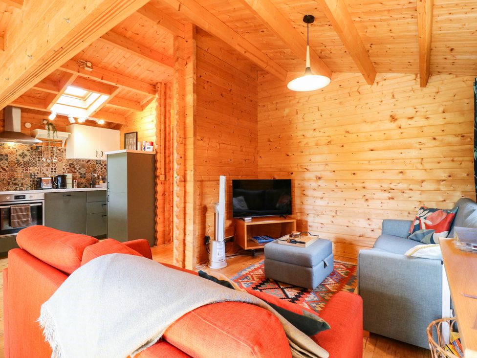 A living room with two sofas and a television at Willow Lodge in Stowmarket
