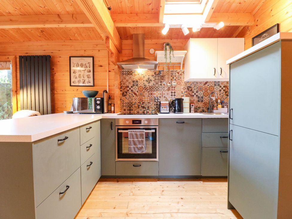 A kitchen with an oven and sink at Willow Lodge in Stowmarket