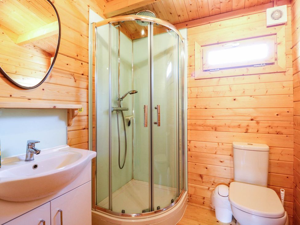 A bathroom with a shower, toilet, and sink at Willow Lodge in Stowmarket