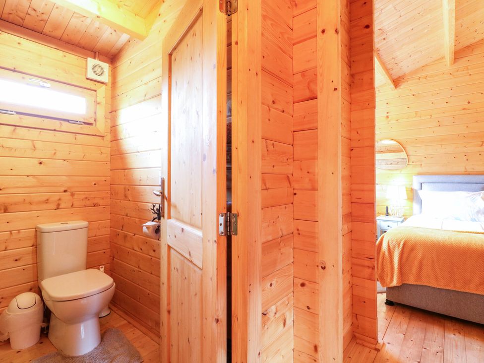 A bathroom with a toilet and sink at Willow Lodge in Stowmarket