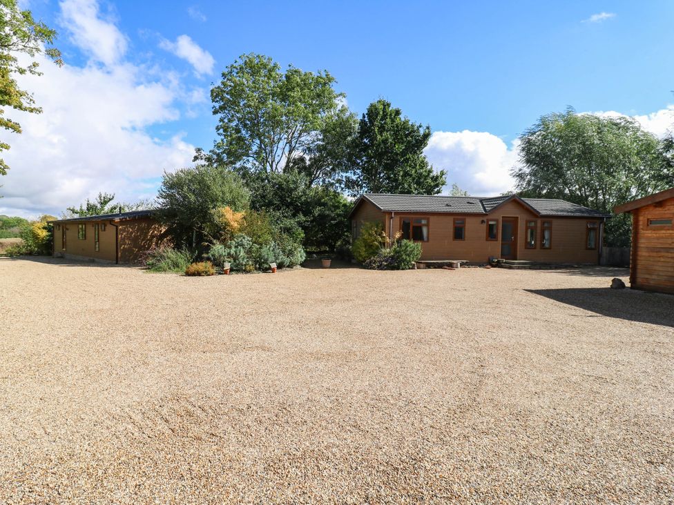 An outdoor area with cabins and gravel at Willow Lodge in Stowmarket