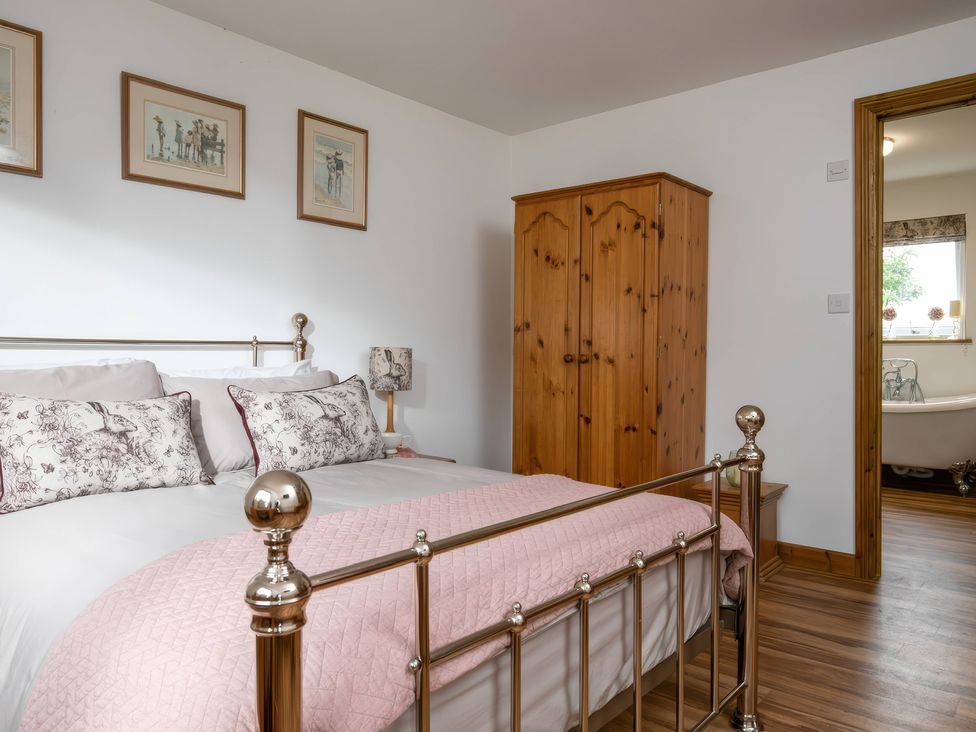 A bedroom with a bed and wardrobe at Willow Cottage in Constantine