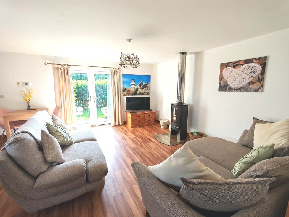 A living room with a fireplace and television at Willow Lodge in Constantine
