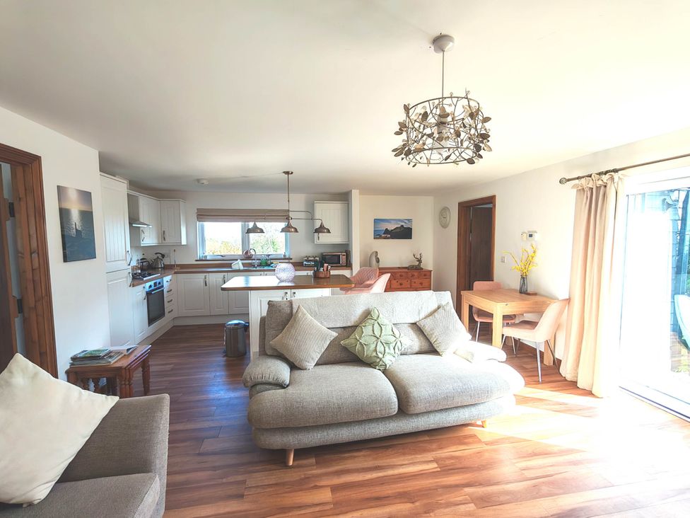 A living room with a sofa and kitchen area at Willow Lodge in Constantine