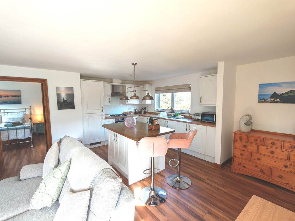 A kitchen with bar stools and cabinets at Willow Lodge in Constantine