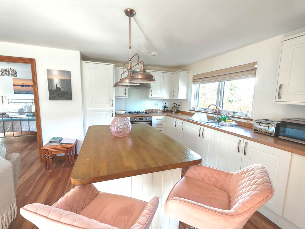 A kitchen with bar stools and a cooking range at Willow Lodge in Constantine