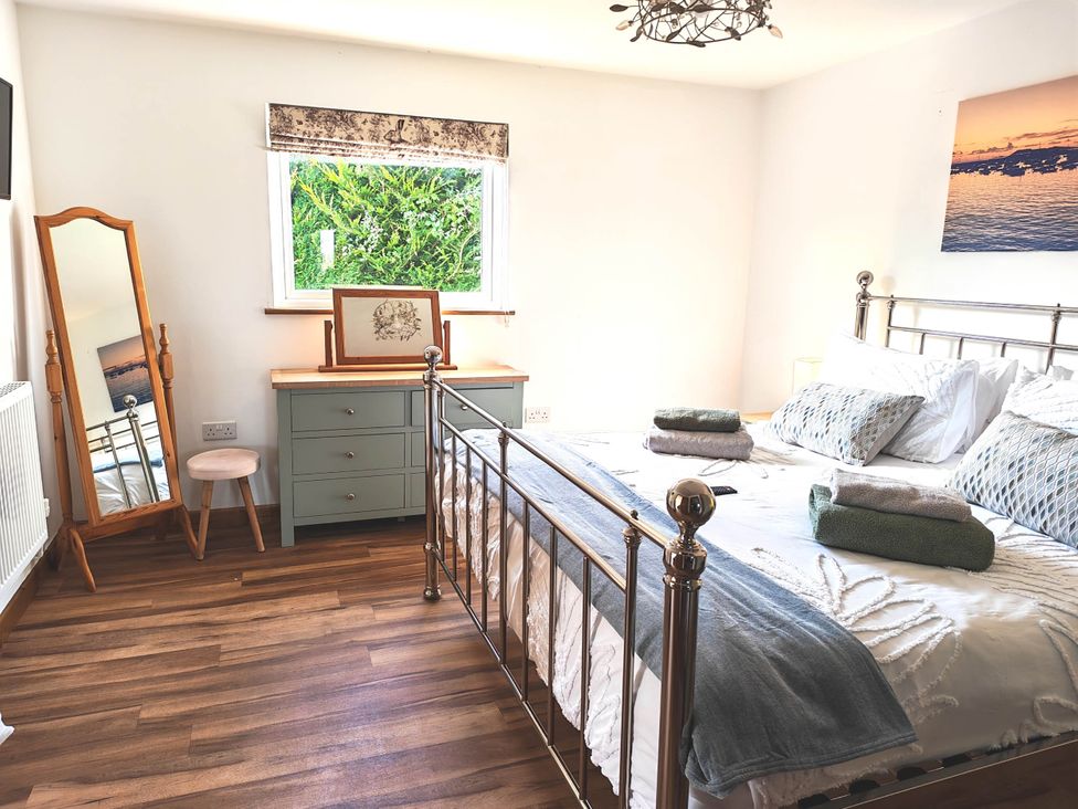 A bedroom with a bed and dressing table at Willow Lodge in Constantine