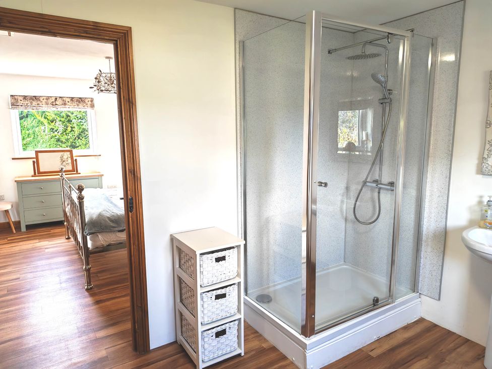 A bathroom with a shower, sink and storage unit at Willow Lodge in Constantine
