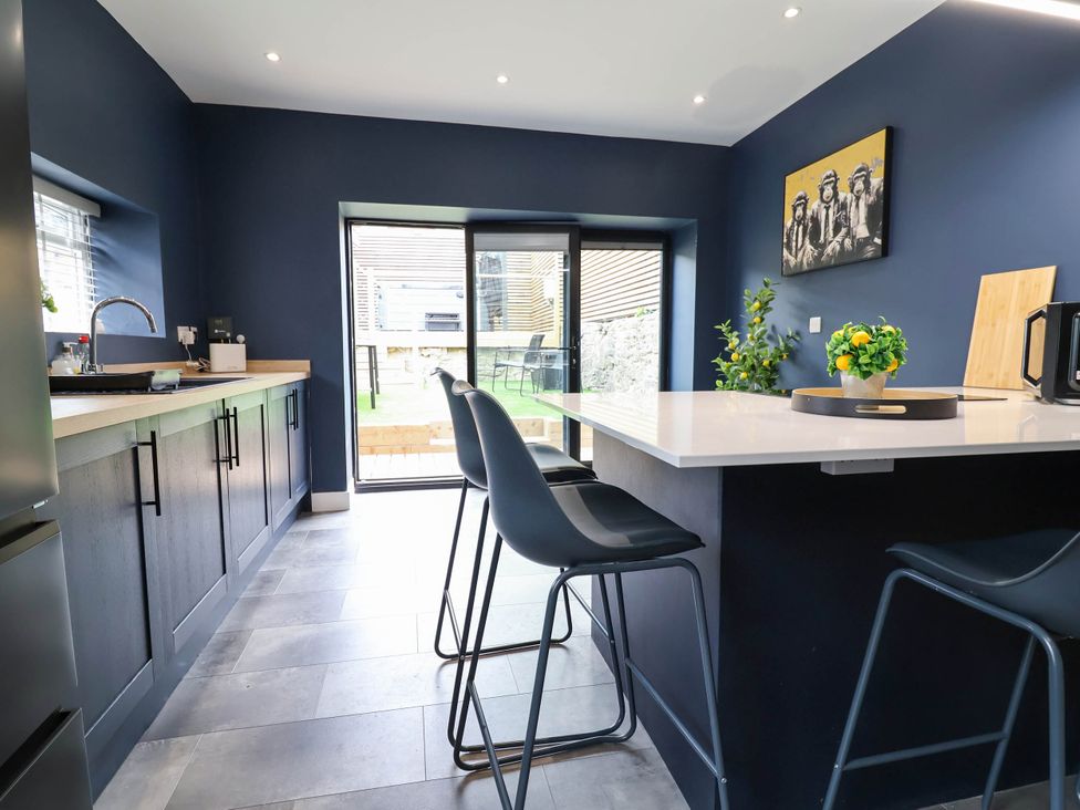 A kitchen with seating area and sliding door at 2 Makant Street in Bolton