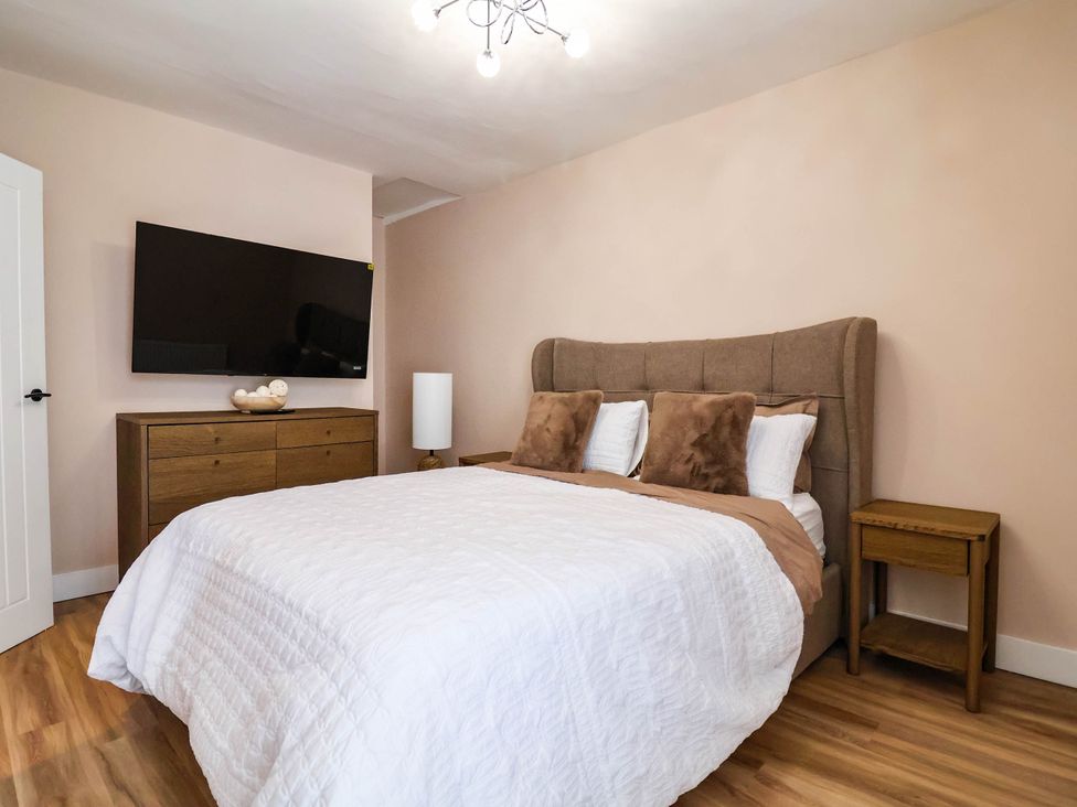 A bedroom with a bed and television at 2 Makant Street Bolton