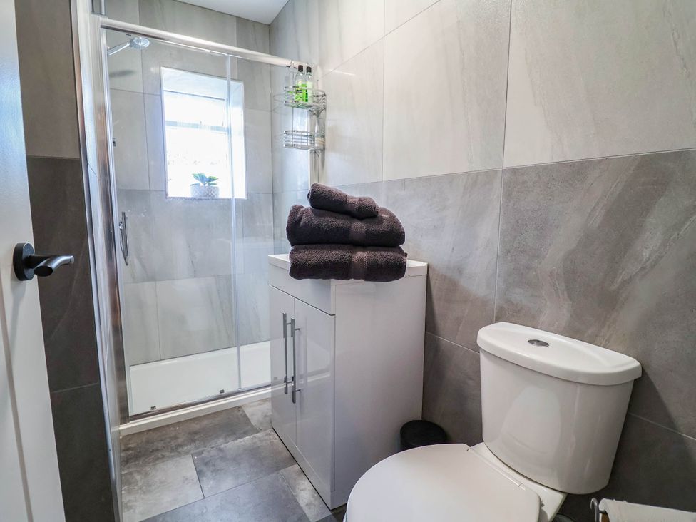 A bathroom with a shower, toilet, and towels at 2 Makant Street Bolton