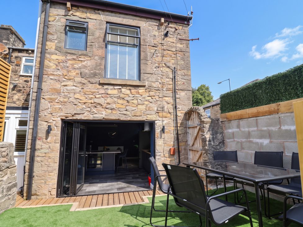 A garden with a stone wall and outdoor furniture at 2 Makant Street in Bolton