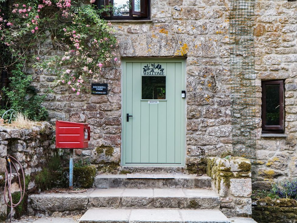An entrance with a green door and red mailbox at Brimble Cottage at Dockwell Farm Newton Abbot