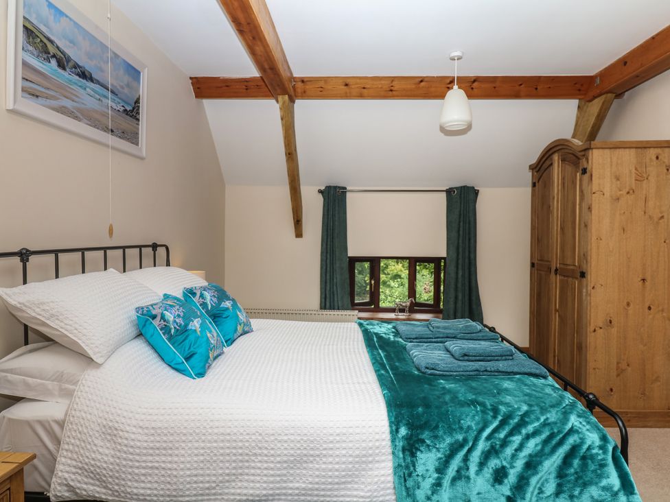 A bedroom with a bed and wardrobe at Brimble Cottage at Dockwell Farm, Newton Abbot