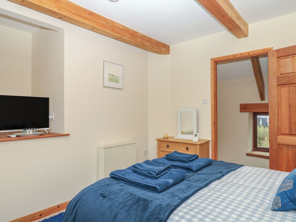 A bedroom with a bed and television at Brimble Cottage at Dockwell Farm Newton Abbot