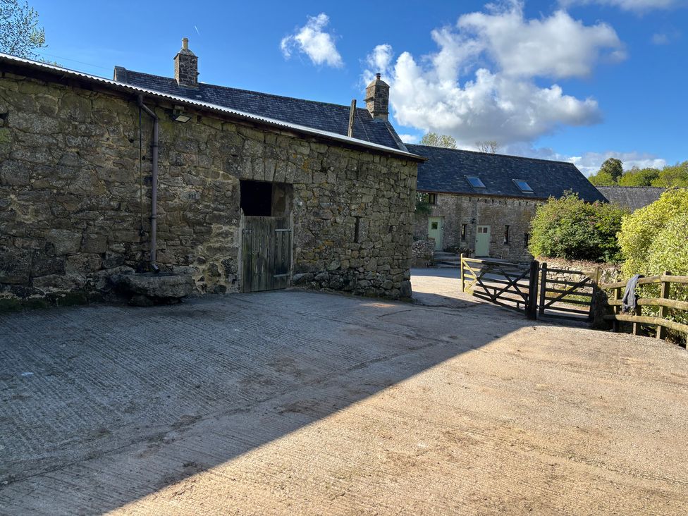 An outdoor area with stone buildings and a gate at Brimble Cottage at Dockwell Farm near Widecombe-In-The-Moor