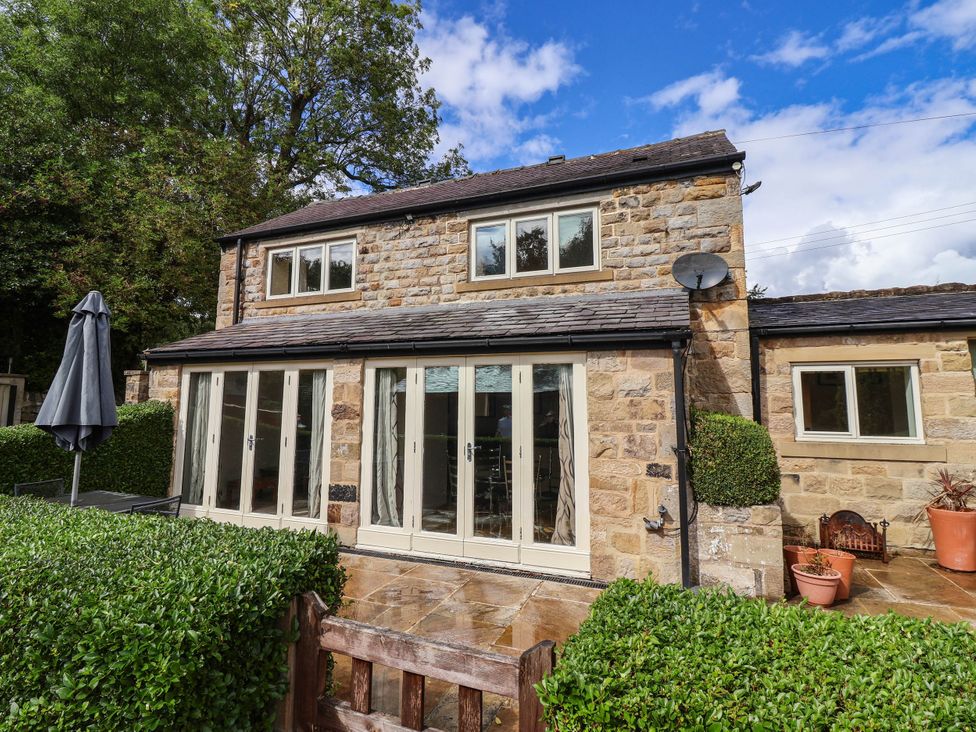 A house with patio doors and windows at Honey Pot Cottage in Harrogate