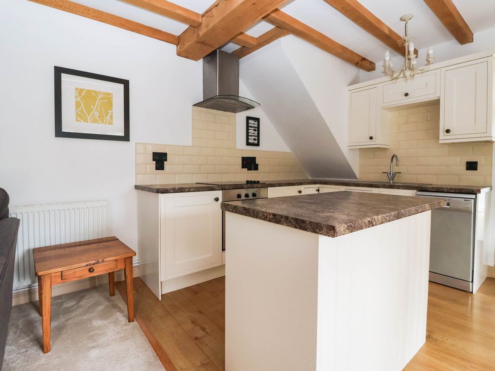A kitchen with cabinets and countertop at Honey Pot Cottage in Harrogate