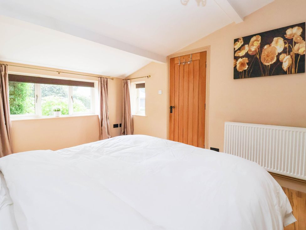 A bedroom with a bed and window at Honey Pot Cottage in Harrogate