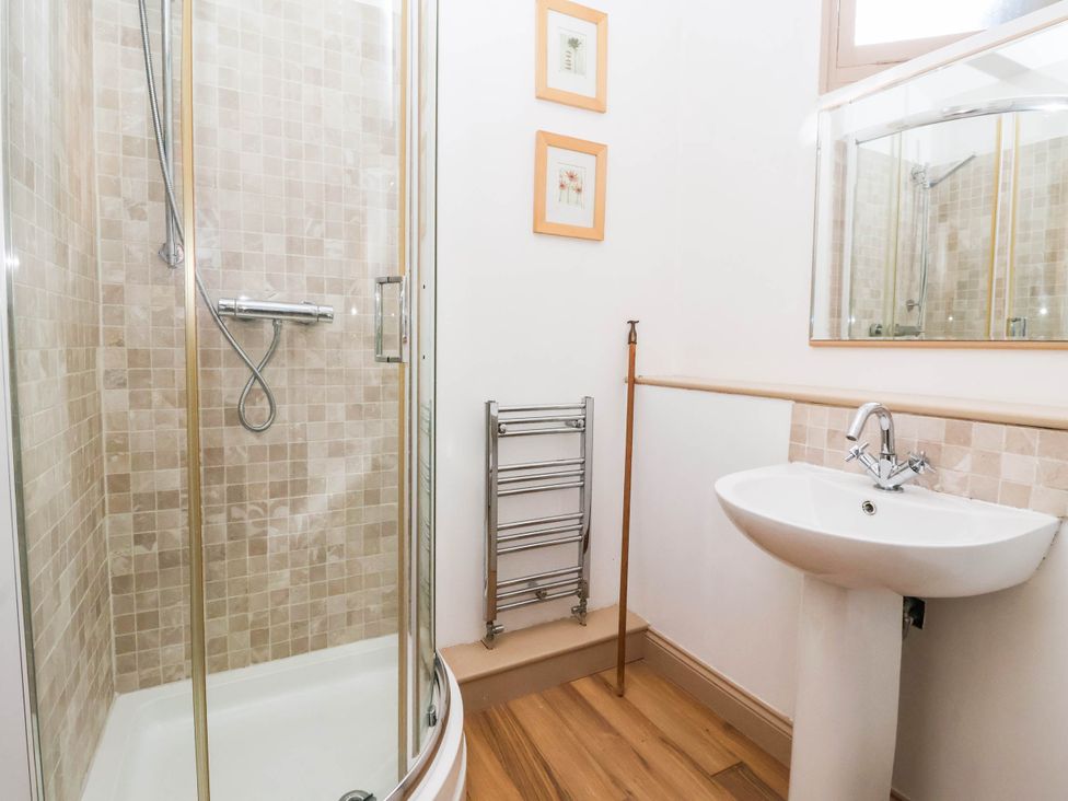 A bathroom with a shower and wash basin at Honey Pot Cottage in Harrogate